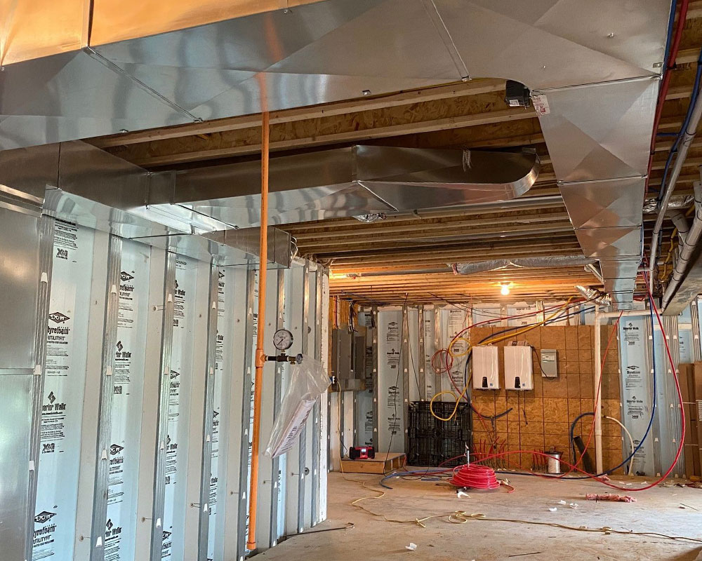 New galvanized sheet metal duct trunks installed in a Halton basement by IKAD Mechanical